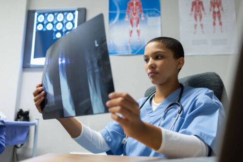 A doctor examines her patient’s X-rays.