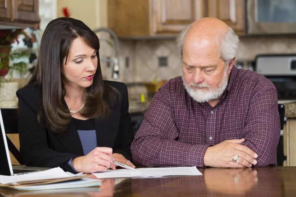 Female Attorney Advising Elderly Male Client Stock Photo