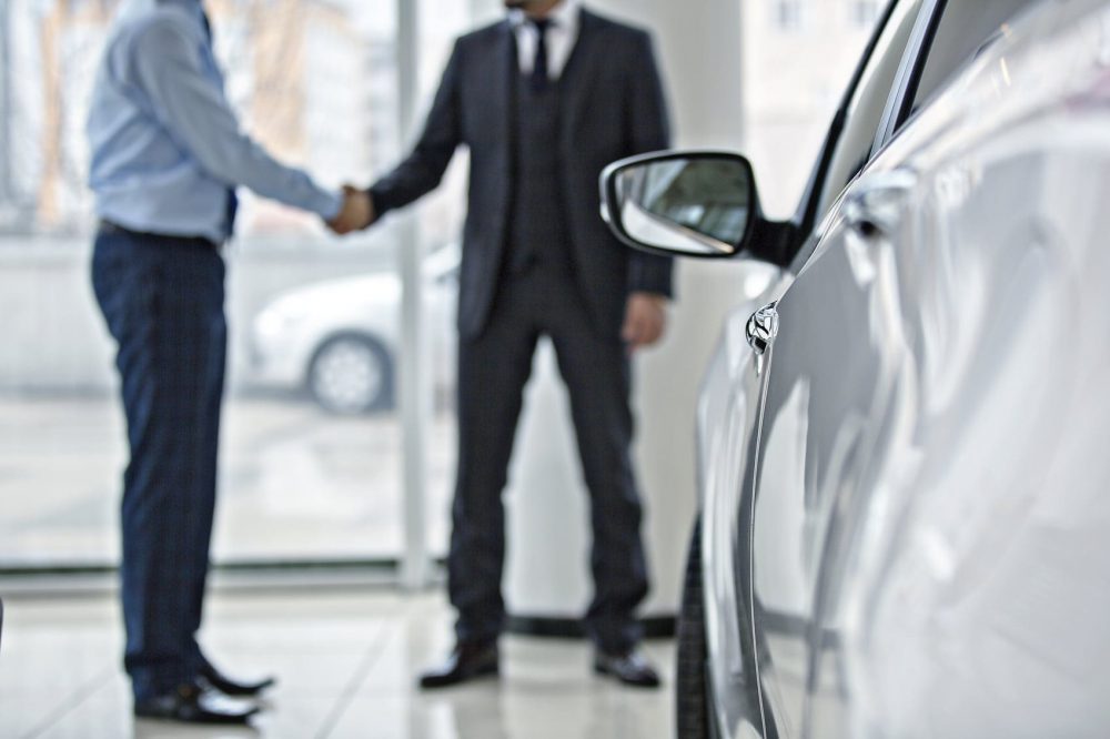 Car Buyer Shaking Hands With Car Salesman Stock Photo