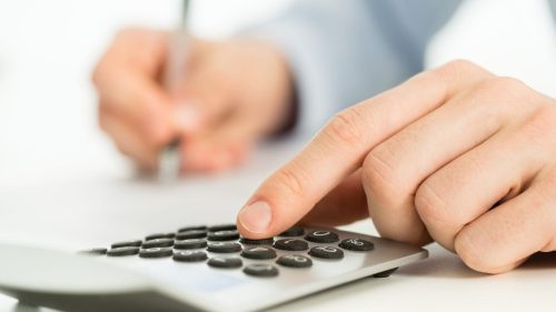 Hand On A Calculator Stock Photo