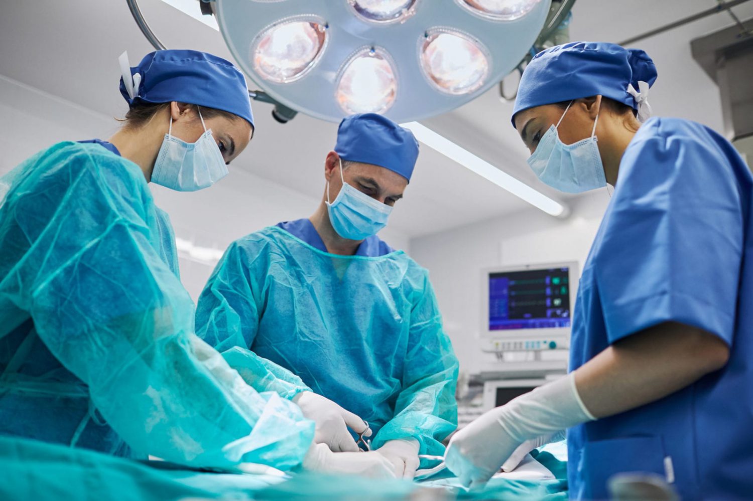 Three Doctors Performing Surgery Stock Photo
