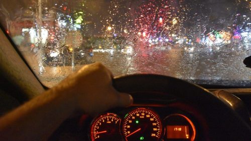Man Driving His Car At Night In The Rain Stock Photo
