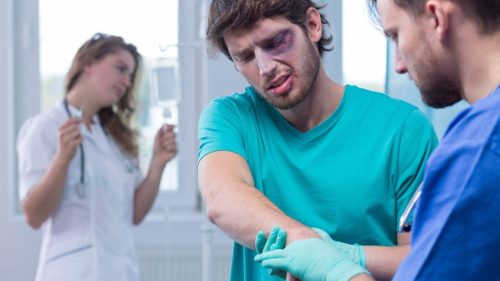 Injured Man Being Examined By A Male Nurse Stock Photo