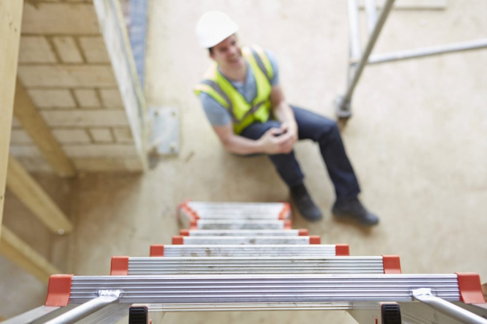 Worker Falling Off Ladder And Injuring Leg Stock Photo