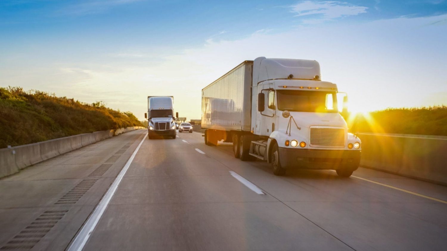 Semi-trucks Driving On The Interstate At Dusk Stock Photo
