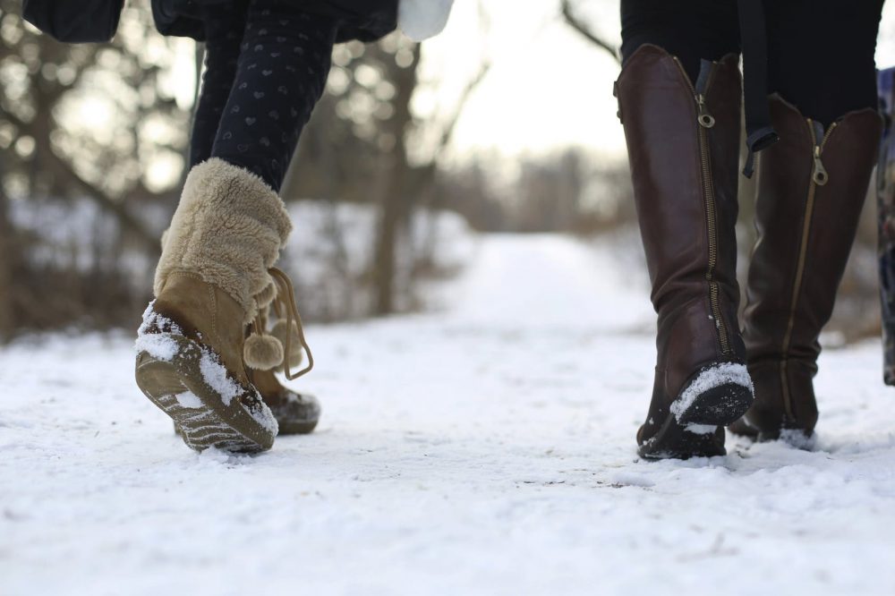 Women In Winter Boots Walking In The Snow Stock Photo