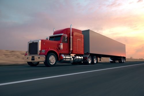 Red Semi-truck Driving On The Interstate Stock Photo