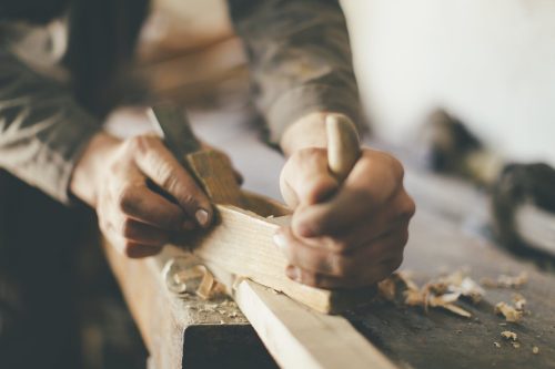 Man Cutting Wood Inside Wood Shop Stock Photo