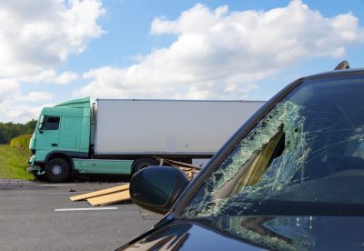 A car with a broken windshield after getting into an accident with a big truck