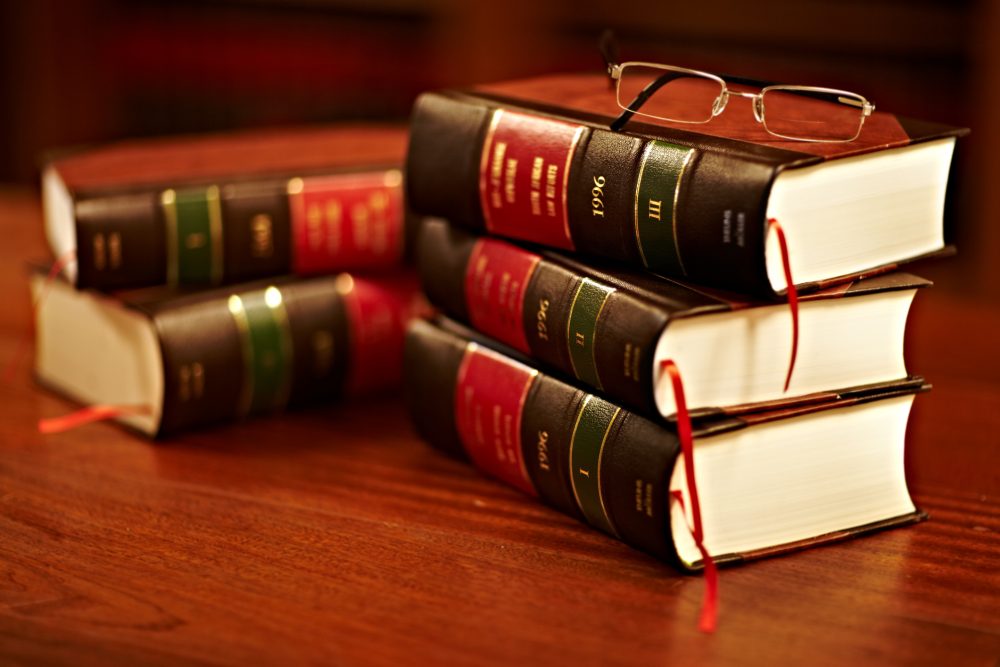 A stack of books about filing a lawsuit sits on the desk of a personal injury lawyer.