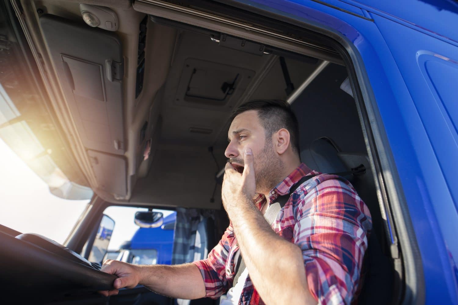 Semi-truck driver yawning while at the wheel about to cause truck accident