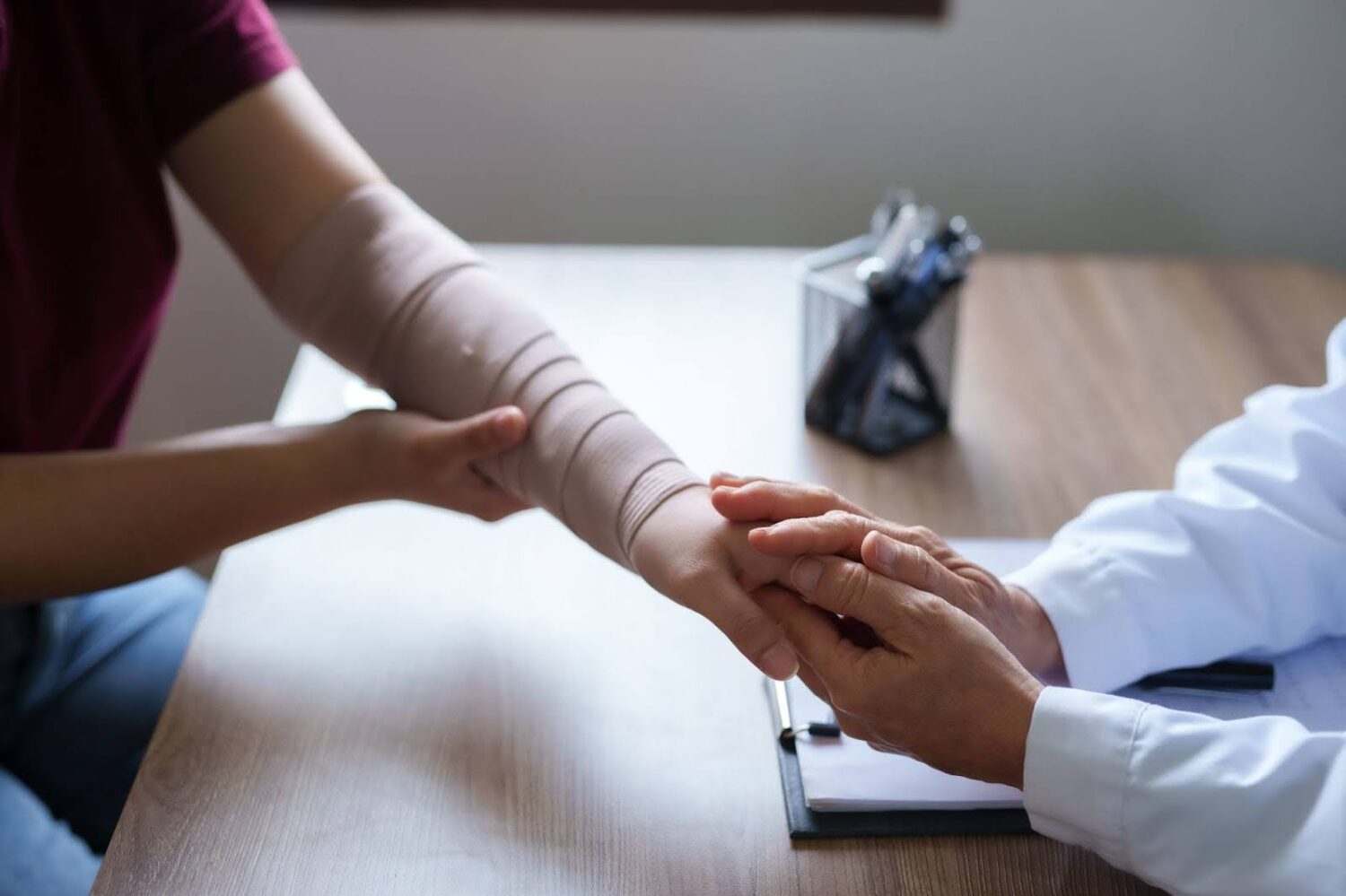 Dr. examines the arm of an injured patient