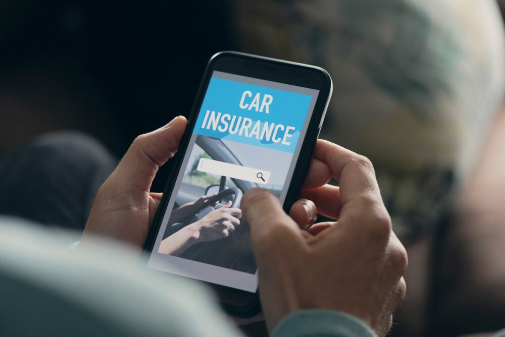 A man searches for car insurance quotes on his phone.