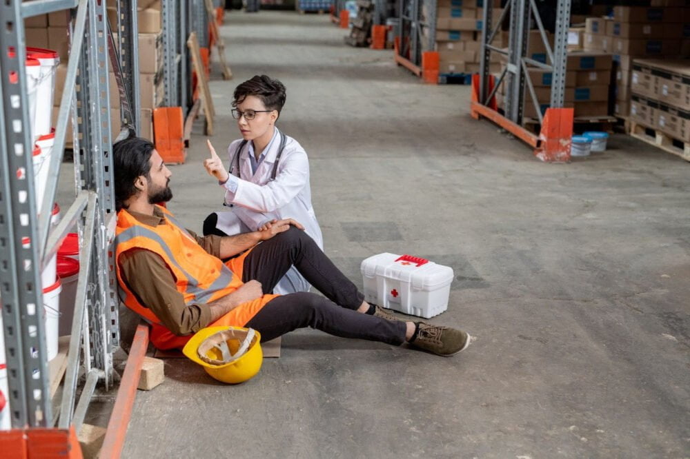 A doctor examines a warehouse worker who has been injured on the job.