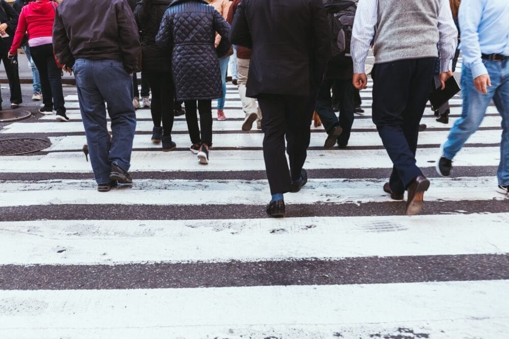 A close-up of people crossing the street at a crosswalk.