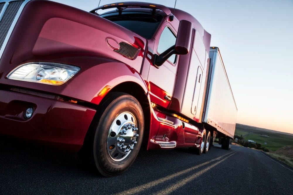 Front to rear low angle view of the cab of a commercial truck on the highway late in the day.