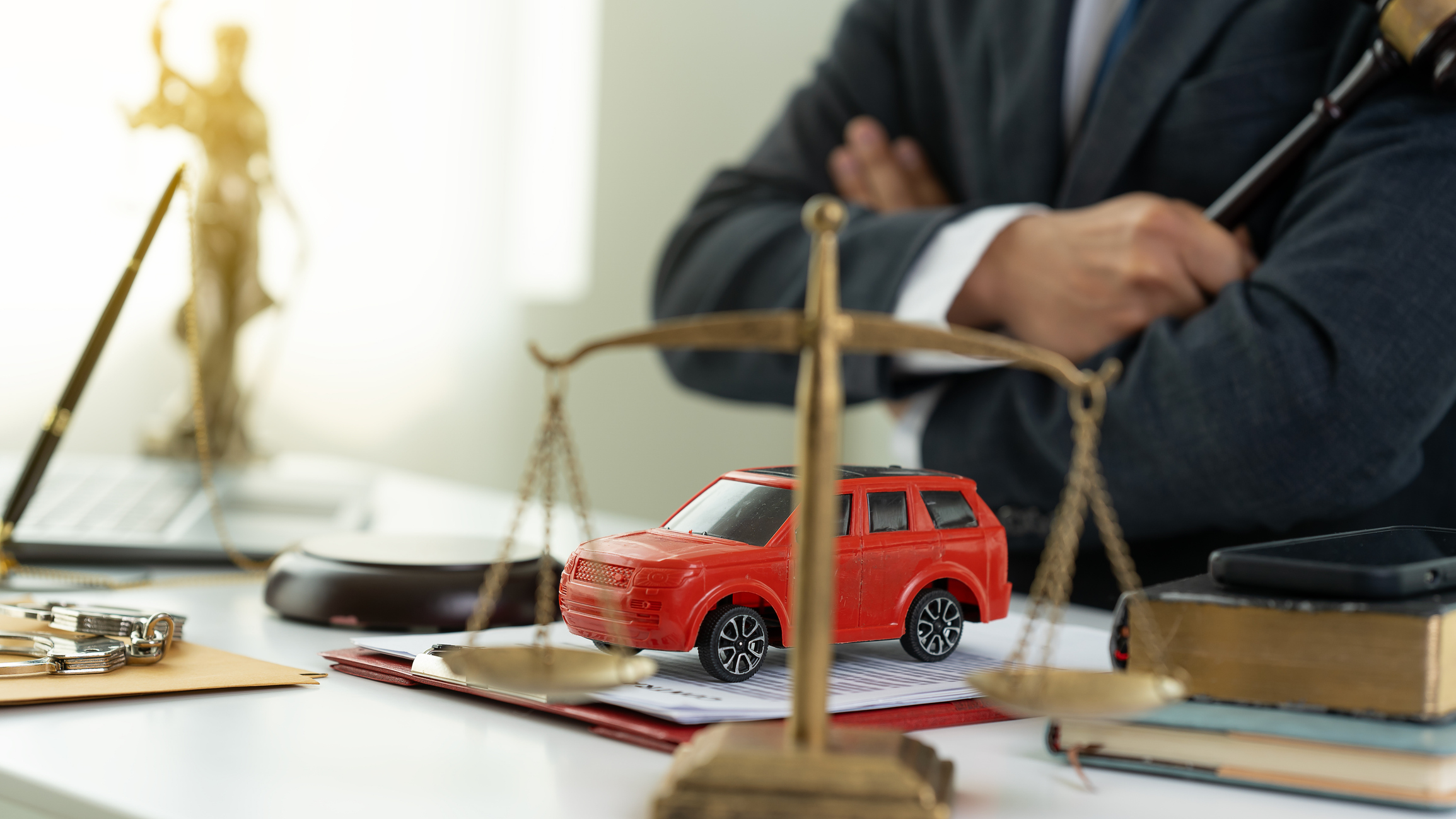 A red model SUV on a car accident lawyer’s desk.